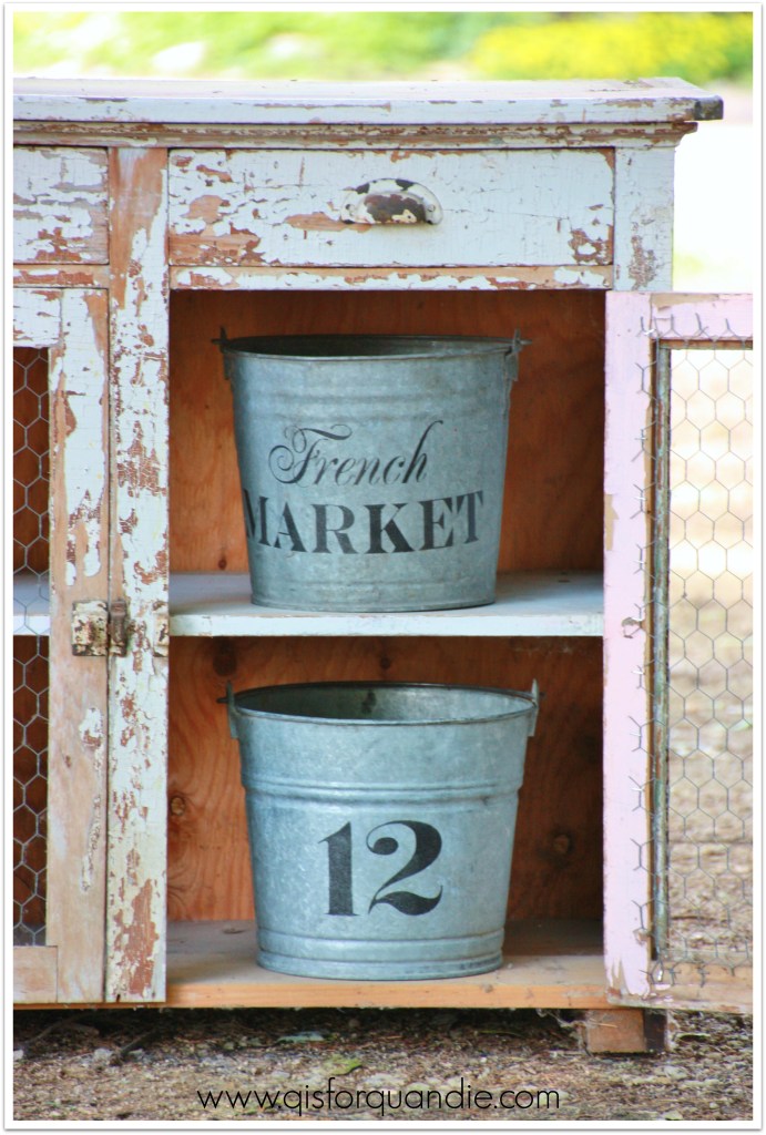 stenciled buckets in cupboard